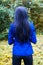 Blue girl from the back. Beautiful woman walking in the dark forest. Back view. blue long hair back view