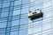 Blue glass facade cleaning with cradle