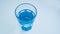 Blue glass with fresh purified drinking water on a light background.