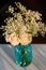 Blue Glass Vase Filled With White Roses and Babies Breath Bouquet on a White Tablecloth