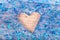 Blue glitter slime with a heart shape hole on a wooden table