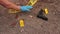 Blue gloved detective hands fixing yellow warning tape do not pass beside crime evidence at crime scene like a gun and bloody