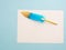 Blue and golden quill pen ron white paper isolated on light blue