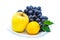 Blue grapes with yellow apple and lemon on a white plate