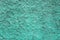 Blue green aquamarine granular wall surface with deep relief and shadows. rough texture