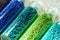 Blue and green beads in bottles for nail design close-up