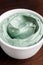 Blue green bentonite clay in a bowl. Clay texture close up. Diy mask and body wrap recipe. Natural beauty treatment and spa.