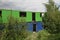 A blue and green containers in storage with the door and window