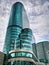 Blue Green Modern Building Against Blue Cloudy Sky