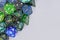 Blue and green roleplaying game RPG dice on side of gray background