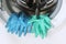 Blue and green rubber gloves are in the open washing machine.
