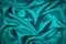 Blue and green silk satin fabric. Elegant teal color background. Liquid wave or silk soft wavy folds.