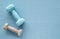Blue and grey dumbbells on the blue fitness mat, top view