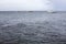 Blue grey sea and sky view photo. Rainy day on seaside. White boats in open sea. Rainy season on tropical island