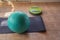 A blue gymnastic ball next to a gym mat.