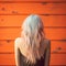 Blue-haired Woman In Retro Filter Style Standing In Front Of Orange Wall