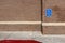 Blue handicapped parking sign on a red brick wall of an office building in the United Sates of America