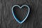 Blue heart shape on crumpled black paper