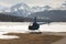 A blue helicopter in the alps switzerland with beautiful mountain and snow covered landscape