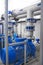 Blue high-pressure pumps engines and gray pipes, water or wastewater treatment facilities inside, industrial interior
