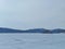 Blue hills rising in the distance above the snow-covered steppe, on which there are traces of people and cars.