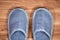 Blue home slippers on a brown wooden floor