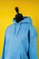A blue hoodie on a mannequin on a yellow background