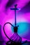 Blue hookah with black rubber tube and blue and white flask on interesting colorful background.