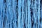 Blue horizontal background or wallpaper with a vertical rhythm. Decor with interwoven tree branches painted in blue. Copyspace