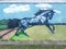 Blue horse jumping on the agricultural hilly meadow, wall paint