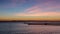 Blue hour sunset with light clouds and pink and orange hues over the Pacific Ocean in Orange County, California.