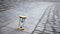 Blue hourglass on stone pavement