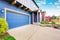 Blue house exterior. View of garage and porch with red entrance door.