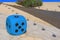 Blue huge gambling cube as a creative decision for urban furniture. Oversize giant blue dice shaped chair with five dots for game