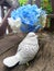 Blue Hydragea flower and bird sculpture on wooden bench