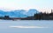 Blue ice of the frozen lake at morning. Winter landscape on the mountains and the frozen lake in Yakutia, Siberia, Russia.