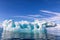 Blue ice iceberg, formed when a glacier calves, floating in the arctic waters of Svalbard, Arctic Circle