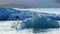 Blue iceberg drifts in salty sea water. Jokulsarlon glacier lagoon in Iceland. Pure blue ice from melting glacier