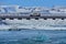 Blue iceberg floating below a passing car at Jokulsarlon Glacier Lagoon