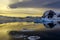 Blue iceberg, mountains and sunset reflecting in ocean at Lemaire Strait, Antarctica