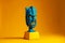 blue indian tiki mask on pedestal on yellow background