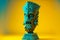 blue indian tiki mask on pedestal on yellow background