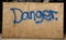 Blue ink graffiti Danger sign on Wooden Board