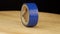 Blue insulating tape rotates 360 degrees on a wooden platform