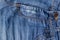 Blue jeans fabric background texture. Distressed denim with seams, front pocket and button