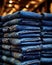 Blue jeans stacked on shelf in store shopping center, sale casual attire denim in showroom