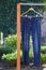 Blue jeans weigh on wooden hanger in yard