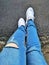 Blue jeans and white sport footwear