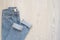 Blue jeans on a wooden background. Flat lay of female styled look. Top view. Shopping Concept. Fashion Outfits