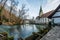 Blue karst spring `Blautopf` with the hammermill and the Blaubeuren Abbey